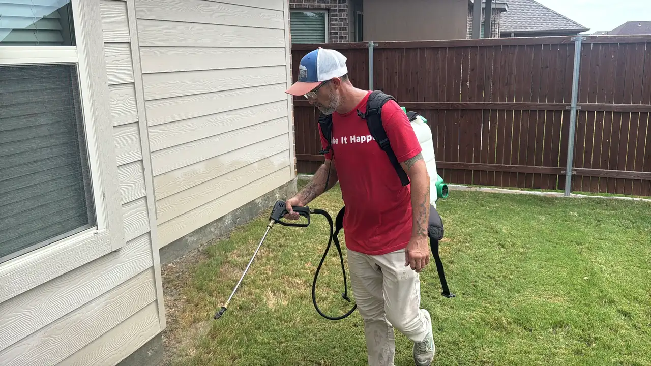 Buffalo Outdoor technician spraying the foundation perimeter of a Fort Worth home with a backpack sprayer